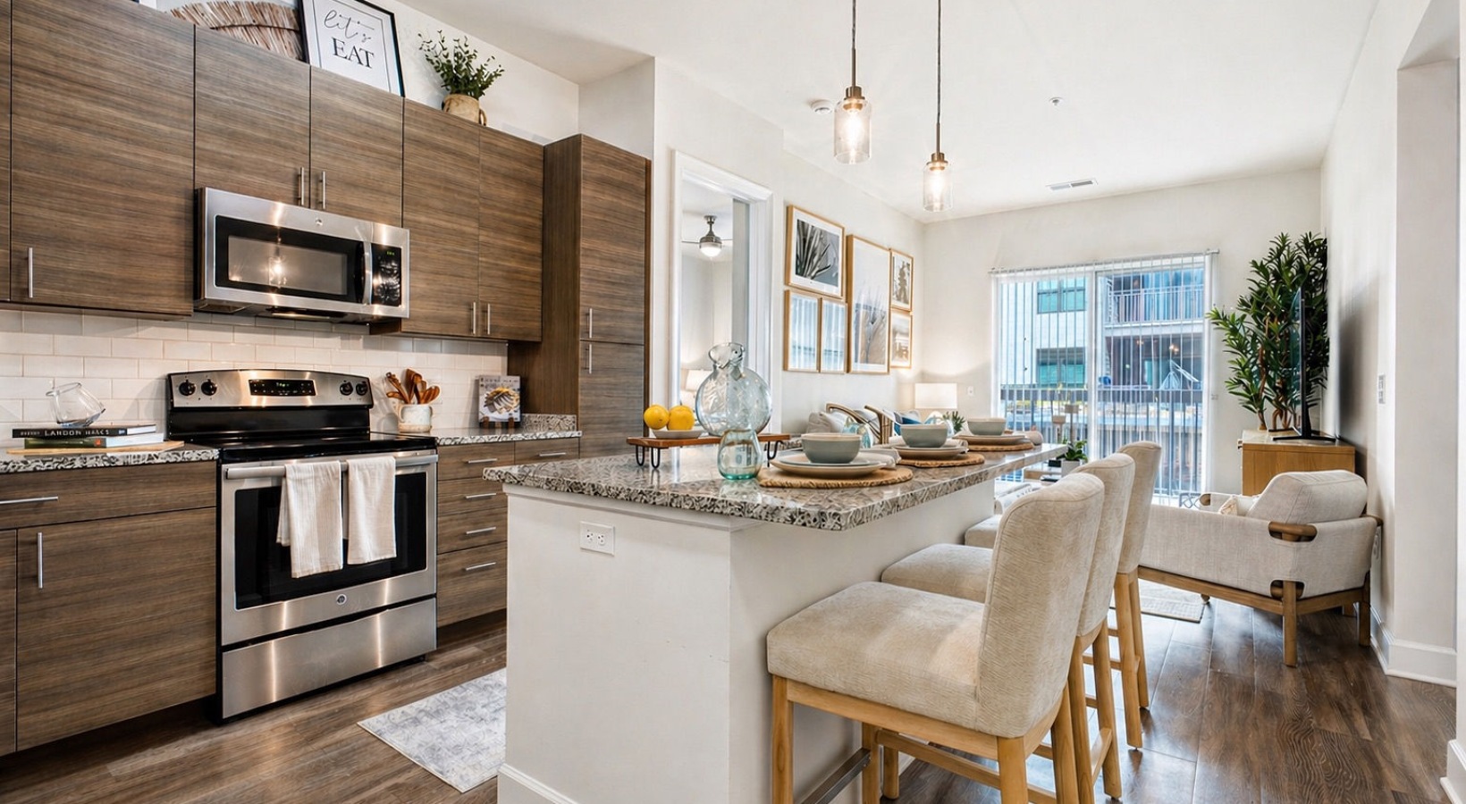  Open-concept kitchen with granite island, bar seating, and stainless steel appliances leading into a bright living area.
